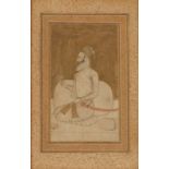 AN INDIAN MINIATURE painted with a Mughal officer in profile kneeling by a cushion and holding a