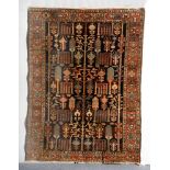 AN ANTIQUE PERSIAN BAKHTIARI DARK BLUE GROUND RUG with continuing tree motif and rust ground foliate