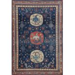 AN ANTIQUE KHOTAN TURKESTAN BLUE GROUND RUG decorated with three circular medallions with