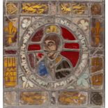 AN EARLY STAINED GLASS SQUARE PANEL with a central figural motif within a multi panel border with