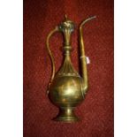 A 19TH CENTURY QAJAR PRESSED BRASS EWER with scroll handle and elongated spout, 42cm high