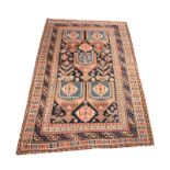 A LURI BLUE GROUND RUG with a central geometric rust ground pattern of medallions within a