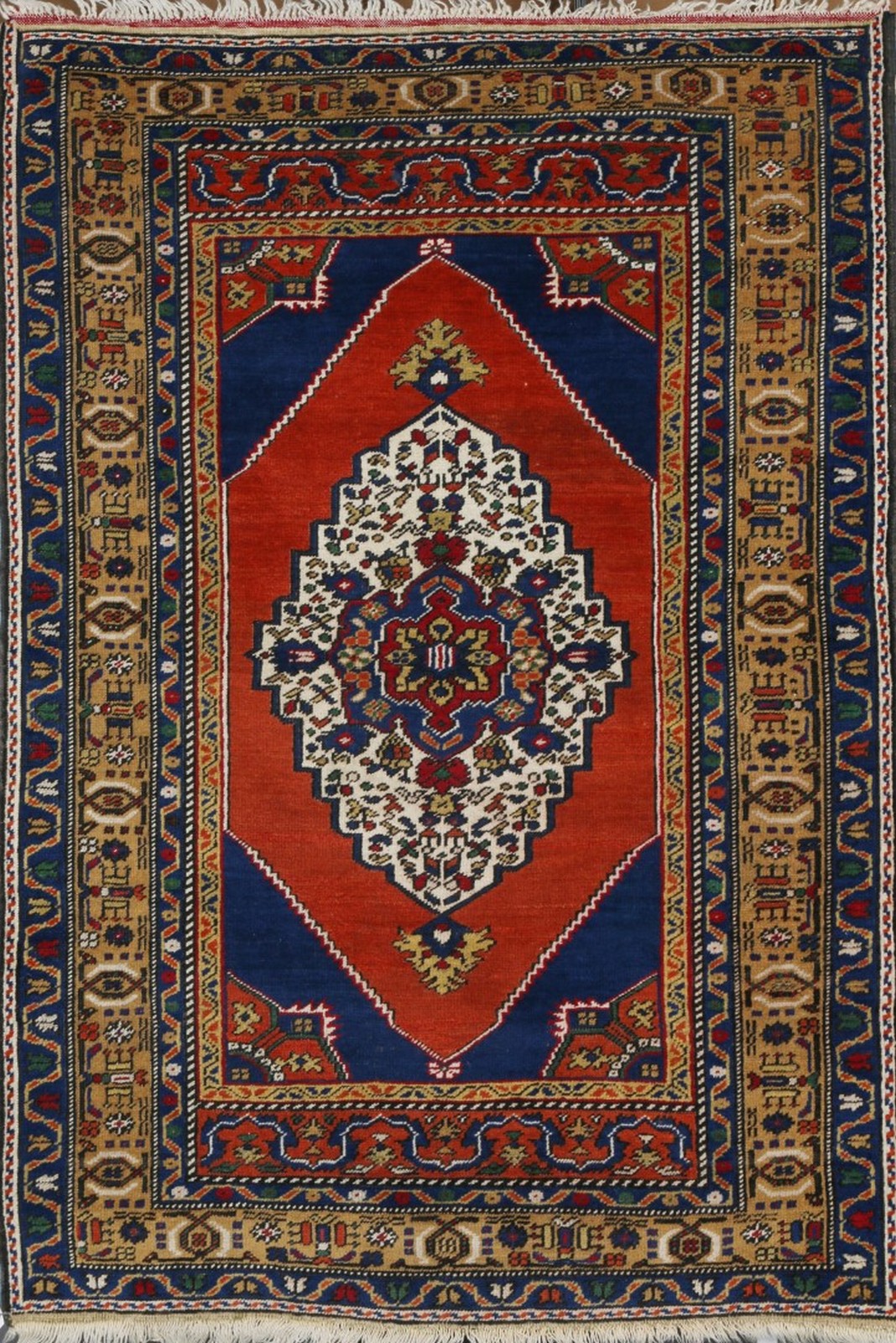 A TURKISH RUST GROUND RUG with a central large medallion within a multi-colour border, 167 x 100cm