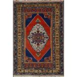 A TURKISH RUST GROUND RUG with a central large medallion within a multi-colour border, 167 x 100cm