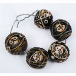 A GROUP OF FIVE MIDDLE EASTERN HARDSTONE BEADS with stylised facial decoration