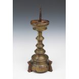 AN ANTIQUE FLEMISH BRASS AND IRON PRICKET CANDLESTICK of graduated urn form with castellated
