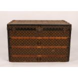 A LOUIS VUITTON RECTANGULAR CABIN TRUNK with stylistic monogram decoration, metal and wooden bound