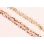 TWO STRINGS OF MINIATURE SNAIL SHELLS, one white, one pink, collected, pierced and strung by