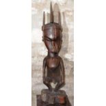 AN INDONESIAN, KALIMANTAN LARGE CARVED WOODEN FIGURE of a man with shaped head dress, star motif and