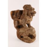 AN ANTIQUE INDIAN CARVED WOODEN TEMPLE FIGURE in the form of a lion astride an elephant, 48cm high x