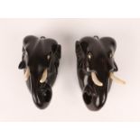 A PAIR OF CARVED EBONY WALL PLAQUES in the form of elephant heads, 13cm high