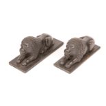 A PAIR OF INDIAN CARVED WOODEN MODELS of crouching lions on a rectangular plinth, 21cm long