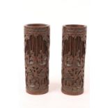 A PAIR OF LATE 19TH CENTURY CARVED BAMBOO BRUSH POTS depicting woodcutters in a forest, 30cm high