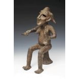 A CAMEROON BRONZE FIGURE of a pipe carrier seated on a stool, 40cm high