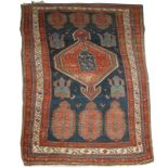 A CAUCASIAN DARK BLUE GROUND TRIBAL RUG with central medallion within a field of ewers and birds and