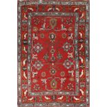 AN ANTIQUE CAUCASIAN TRIBAL RUG with interlinked star motifs on a rose red ground with multiple