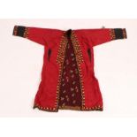 A TURKOMAN CRIMSON SILK EMBROIDERED CHAPAN ROBE with stylised hooked and foliate decoration
