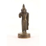 A CEYLONESE MINIATURE BRONZE of a standing Bhudda on a circular base, 8cm high