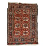 AN ANTIQUE BELOUCH RUG with two rows of four guls on a rust brown field with diagonal end borders,