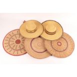 TWO FULANI STRAW HATS and three straw flat baskets with polychrome decoration, approximately 47cm