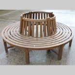 A circular teak bench, in four sections,