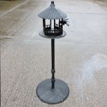 A black painted metal bird feeder, on st