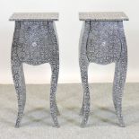 A pair of embossed white metal bedside c