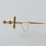 A yellow metal and ruby set pin, in the