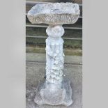 A reconstituted stone bird bath, on a co