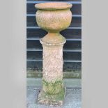 A red terracotta planter, on a column ba