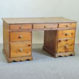 A modern pine desk, on a pedestal base,