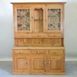 A modern pine dresser, with drawers and cupboards below,