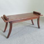 A mahogany window seat, on sabre legs,