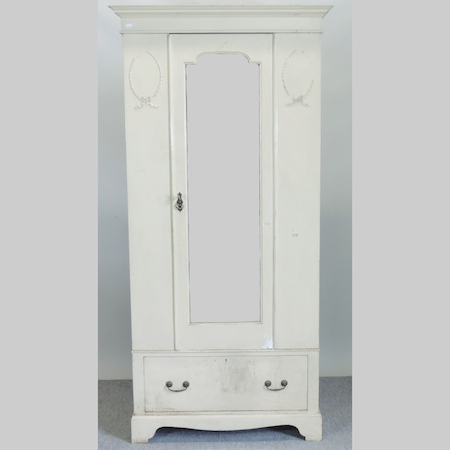 A cream painted single wardrobe, with a drawer below,