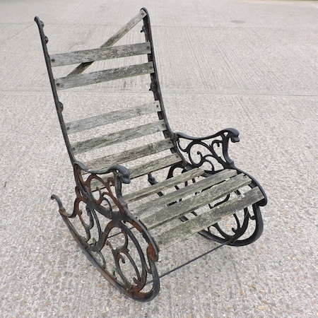 A cast iron and slatted hardwood garden rocking chair