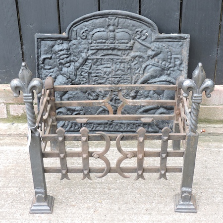 A cast iron fire back with a heraldic motif, dated 1635, 60cm,