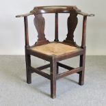 A George III oak rush seated corner chair