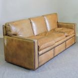 A brown leather upholstered and studded three seater sofa,