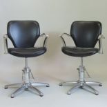 A pair of black upholstered and chrome swivel adjustable armchairs