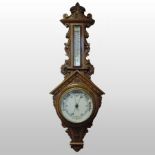 An early 20th century carved oak cased aneroid barometer,