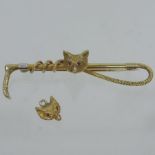 A gold and ruby set bar brooch of hunting interest, in the form of a foxes head,