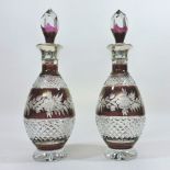 A pair of ruby overlaid cut glass decanters and stoppers,