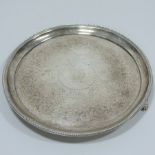 A Victorian silver waiter, of circular shape, with a beaded border, on three paw feet,