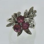 An 18 carat white gold diamond and ruby cluster ring, of asymmetrical design,