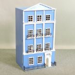 A painted wooden dolls house, containing dolls furniture,