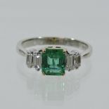 An 18 carat white gold emerald and diamond ring,