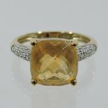 A 9 carat gold and citrine ring, with diamond shoulders,