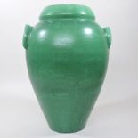 An early 20th century Branham green glazed pottery twin handled vase, of swollen shape,