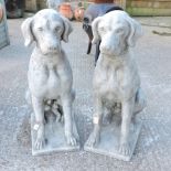 A pair of reconstituted stone models of seated dogs,