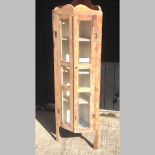 An antique pine glazed standing corner cabinet,